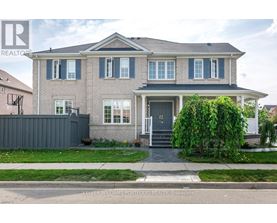 A house with a grey front yard and a white fence.