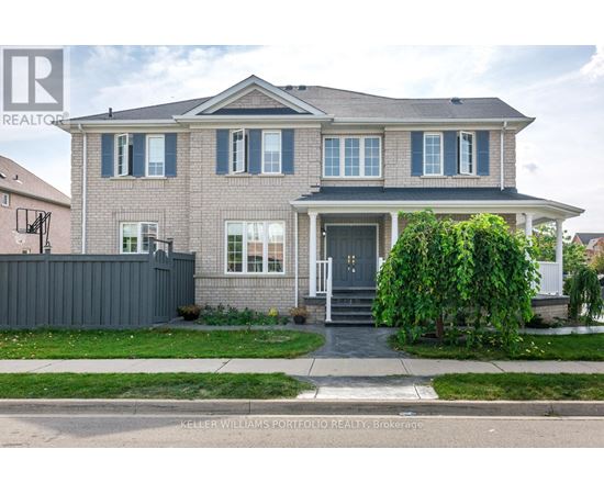 A house with a grey front yard and a white fence.