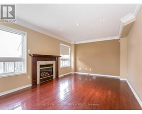 A spacious room with a fireplace and wood flooring.