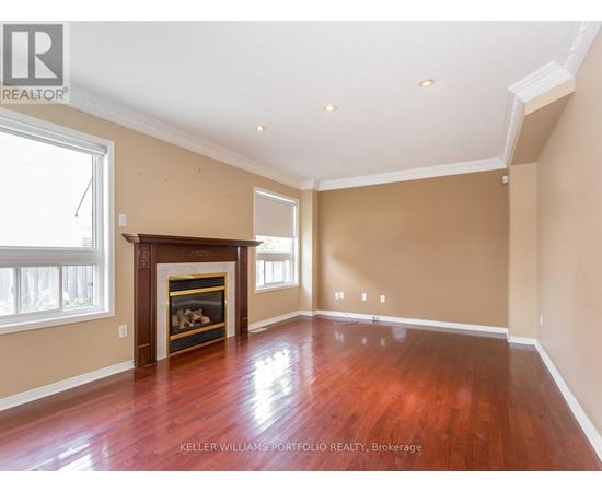 A spacious room with a fireplace and wood flooring.