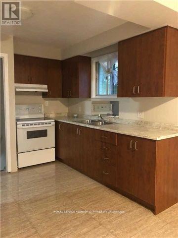 A kitchen with wooden cabinets and a white stove top oven.