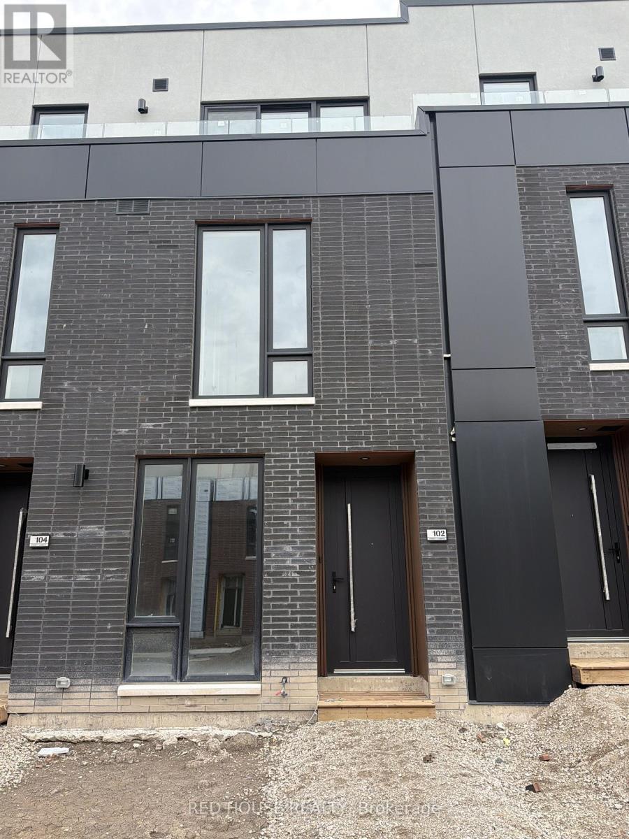 A modern building with a grey facade and black doors.