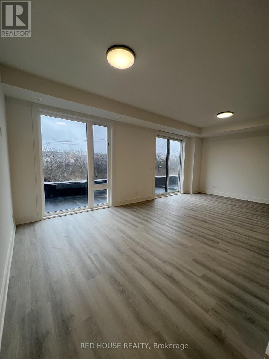 A room with wooden flooring and a large window overlooking a field.