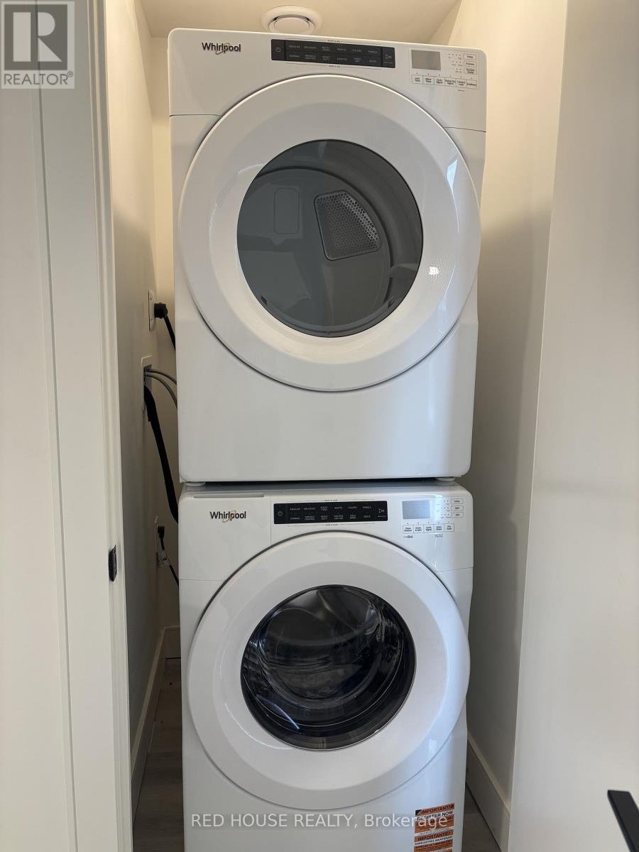 Two white Whirlpool washing machines stacked on top of each other.