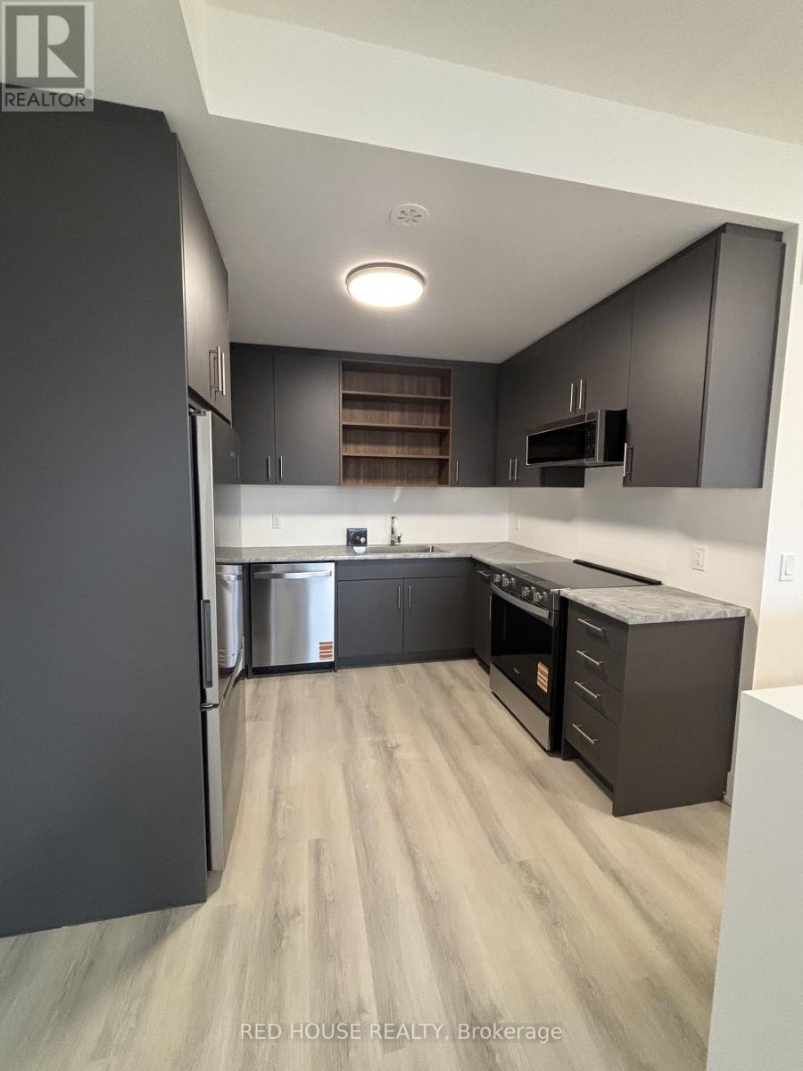 A modern kitchen with dark wood cabinets and stainless steel appliances.