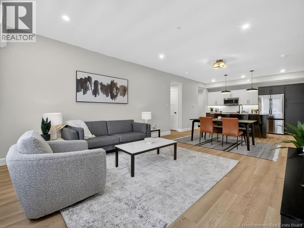 A modern living room with a grey sofa and a grey rug.