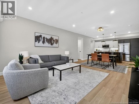 A modern living room with a grey sofa and a grey rug.