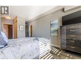 A bedroom with a large bed and a wooden dresser.