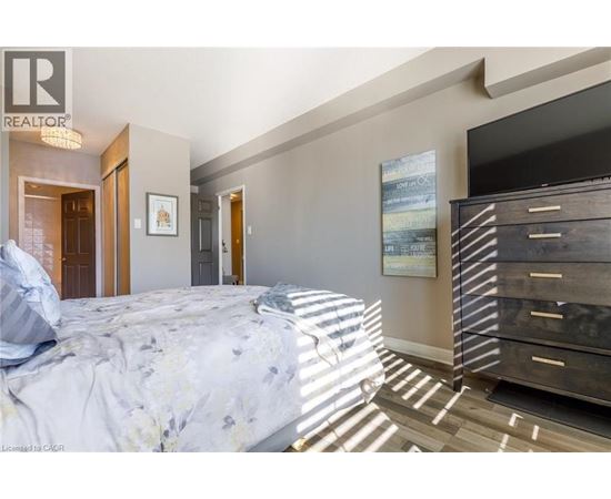 A bedroom with a large bed and a wooden dresser.