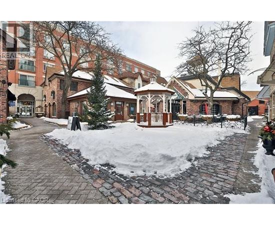 A gazebo sits in the middle of a snow-covered courtyard.