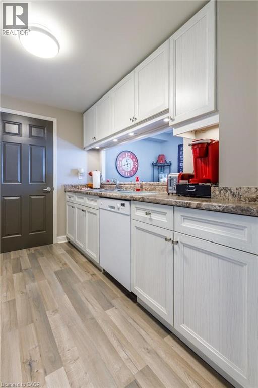 A kitchen with white cabinets and a wooden floor.