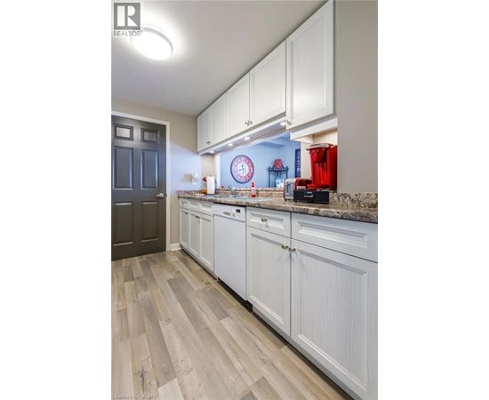 A kitchen with white cabinets and a wooden floor.