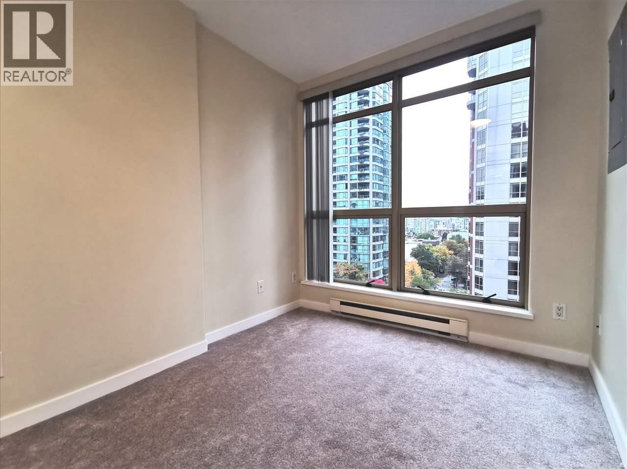 A room with a large window overlooking a cityscape.