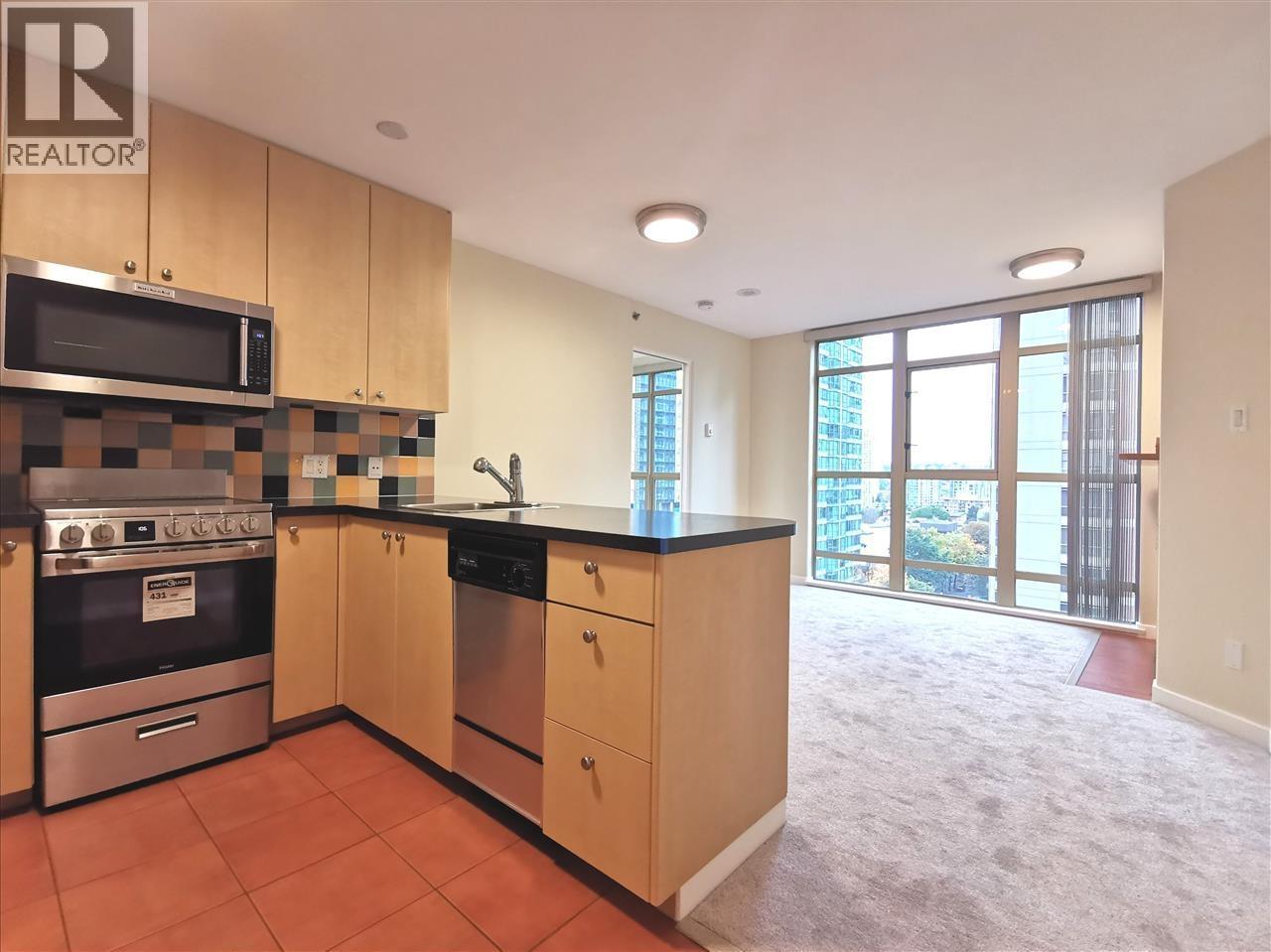 A kitchen with a microwave, oven, and sink.