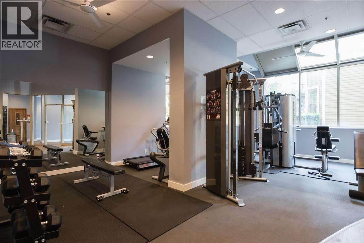A gym with a variety of equipment including treadmills, weights, and exercise machines.