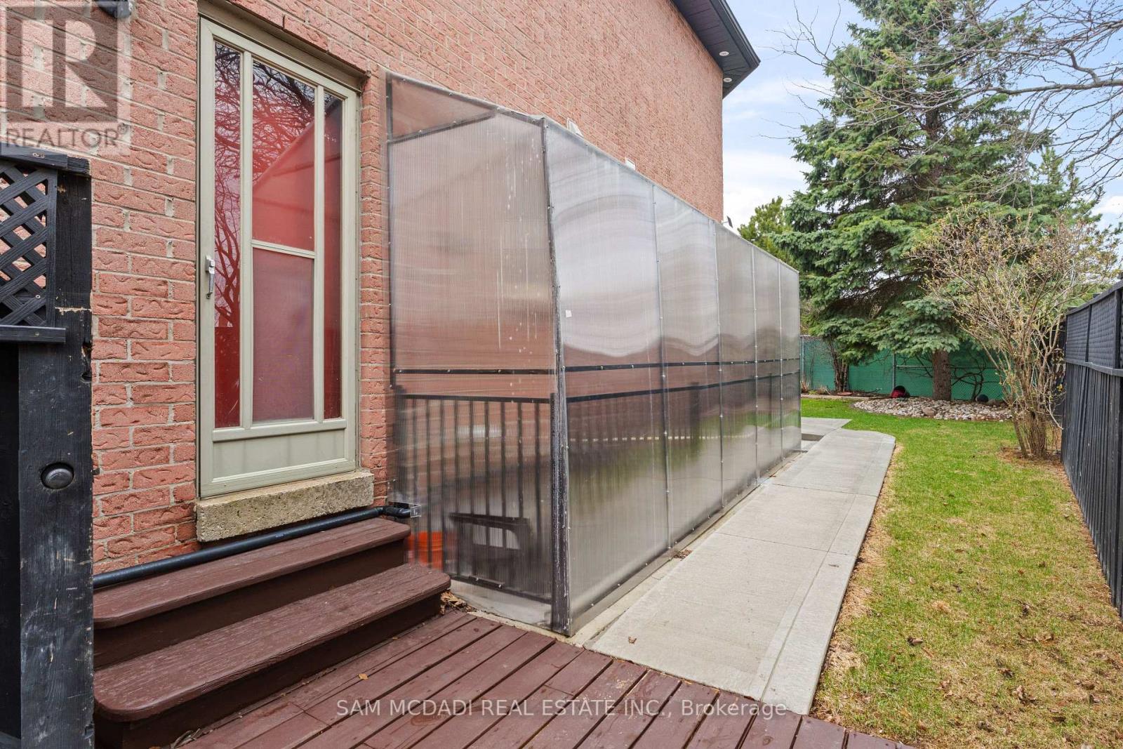 A brick building with a glass fence and a sign that says "REALTOR" on it.