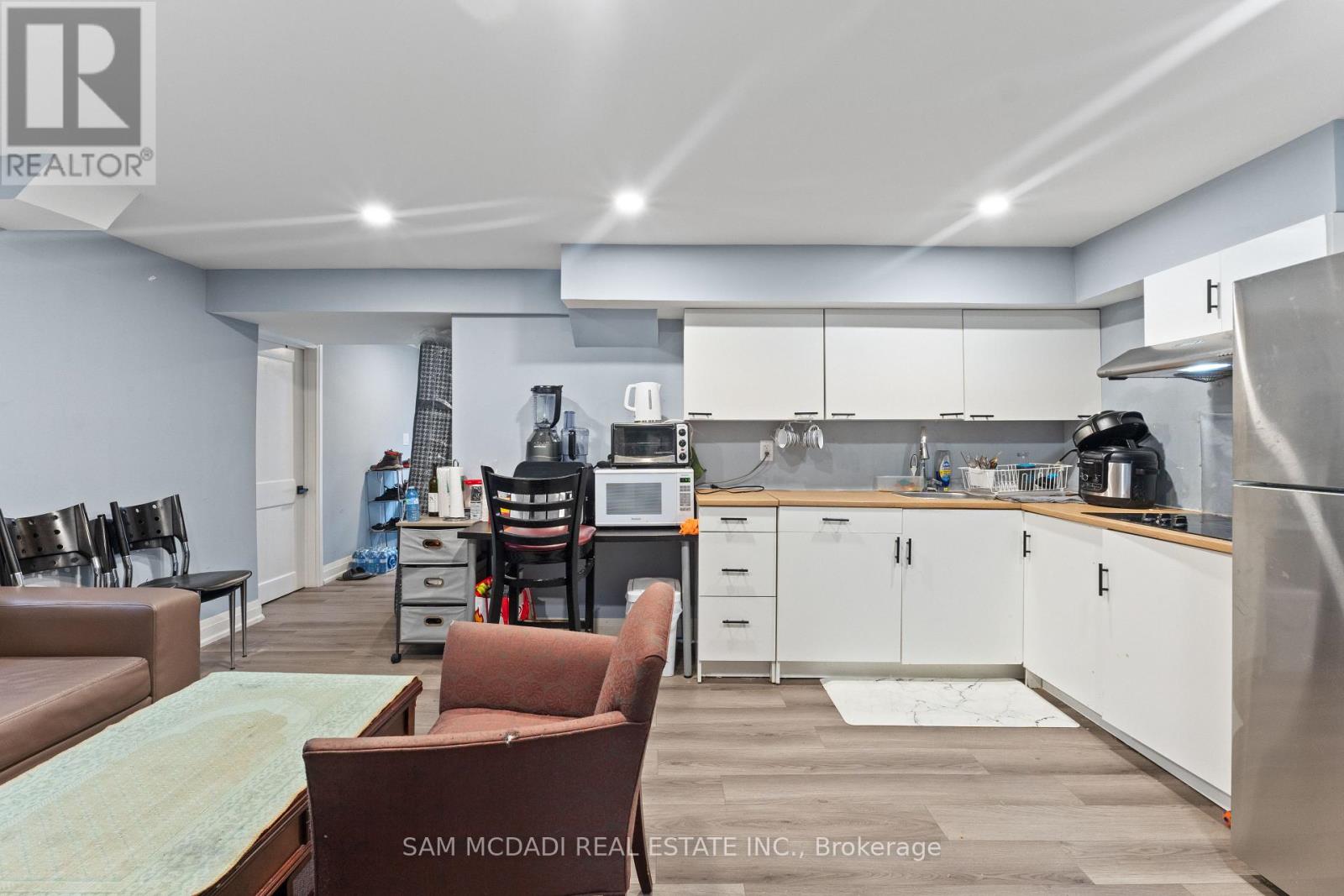 A kitchen with a refrigerator, microwave, and oven.