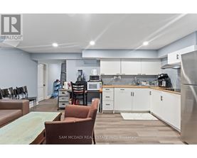 A kitchen with a refrigerator, microwave, and oven.