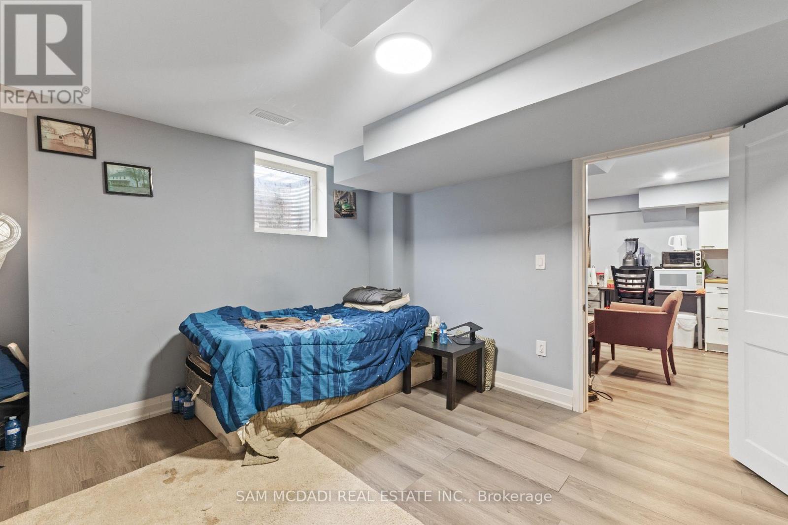A bedroom with a bed covered in a blue blanket.