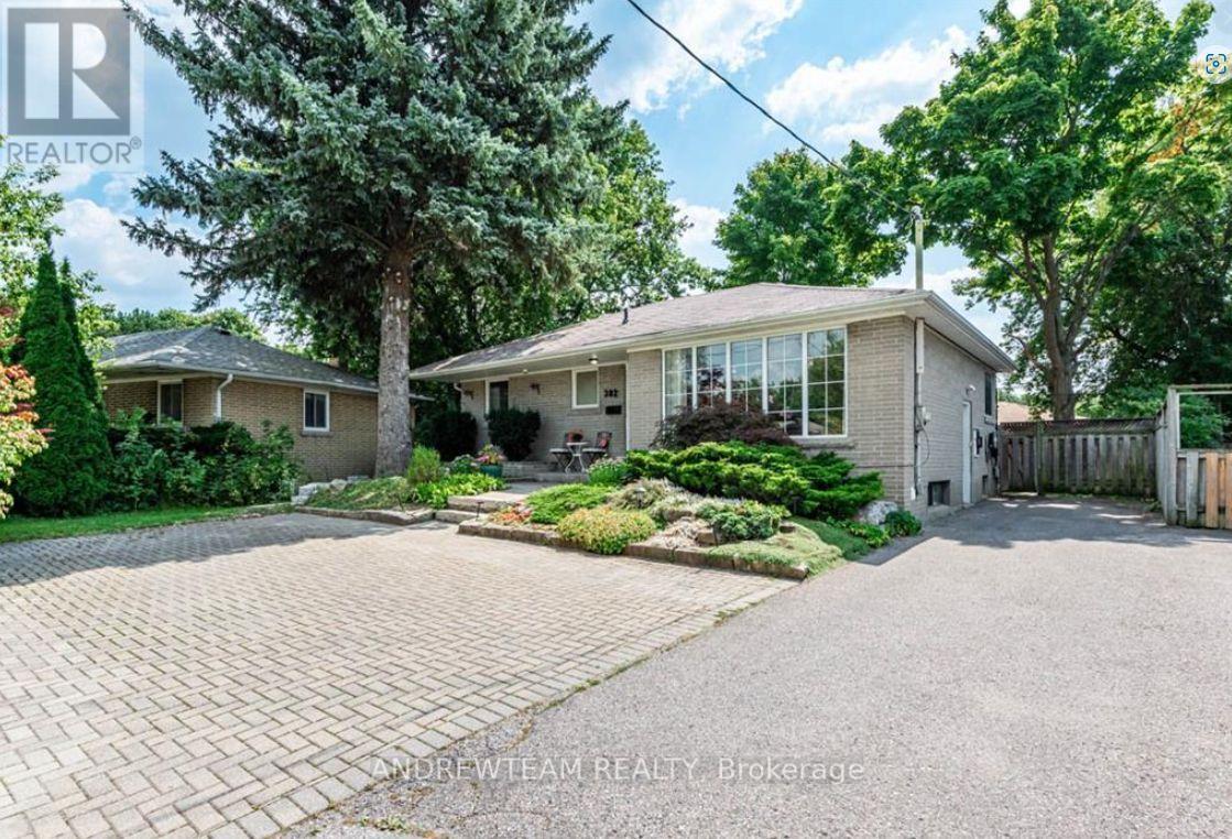 A house with a driveway and trees in front of it.