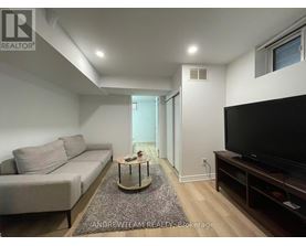 A living room with a grey couch, a coffee table, and a flat screen TV.