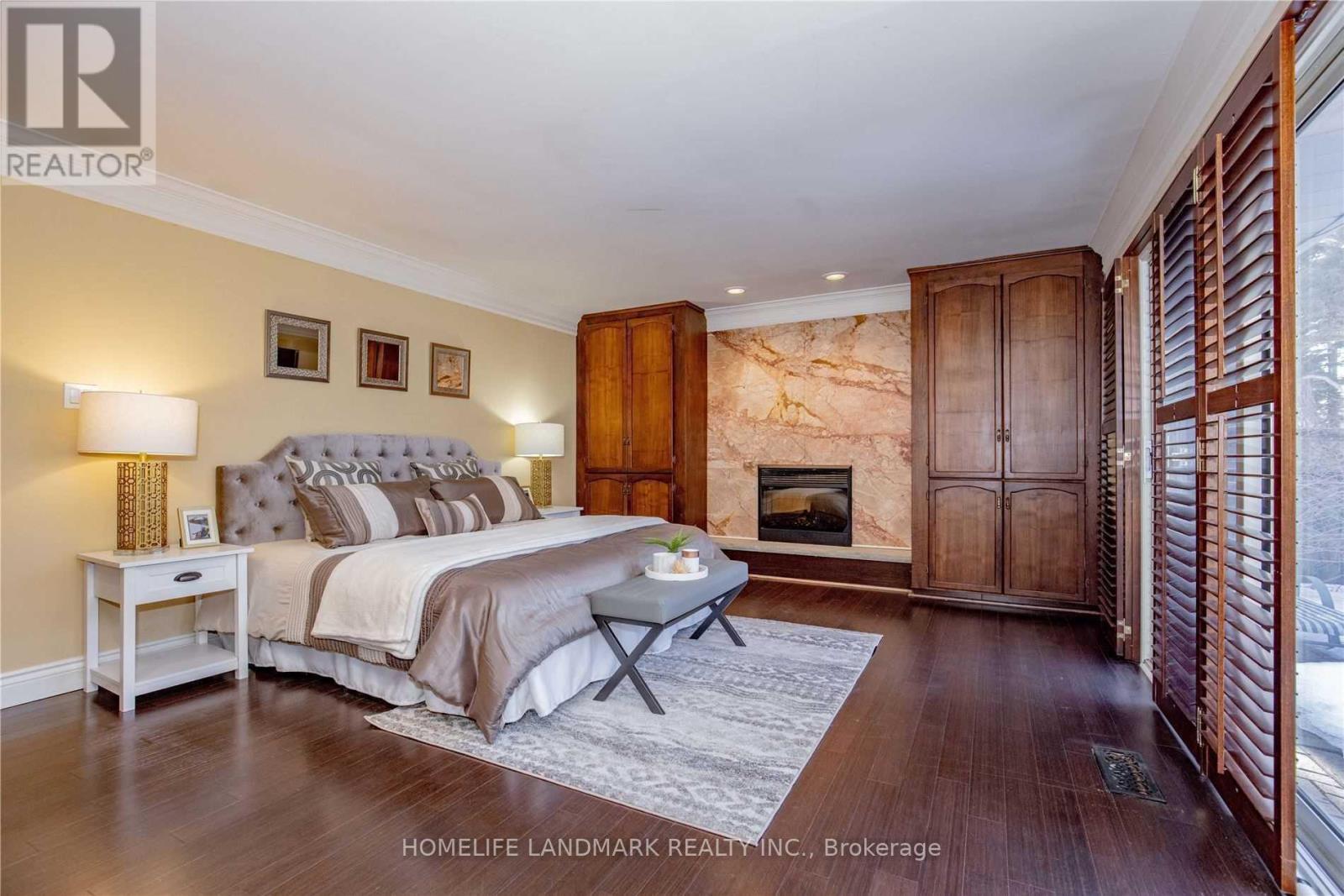 A bedroom with a large bed and a fireplace.