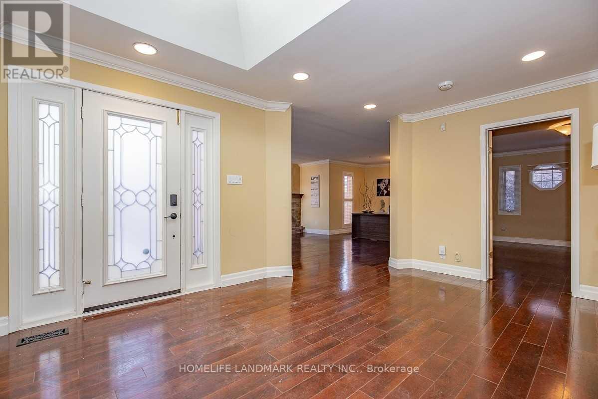 A spacious room with wood flooring and a skylight.