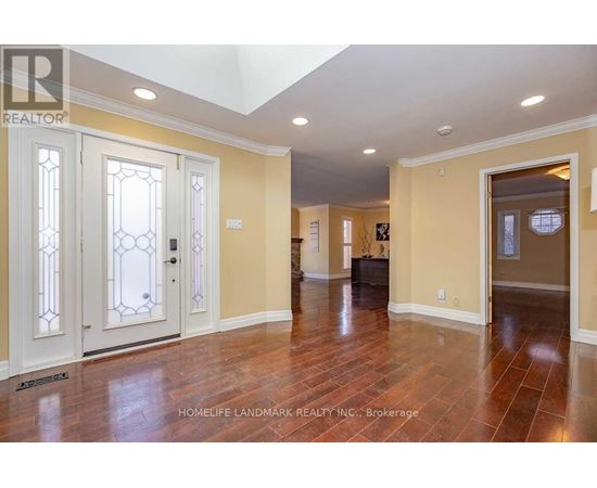 A spacious room with wood flooring and a skylight.