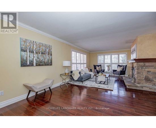 A living room with a fireplace and a painting on the wall.