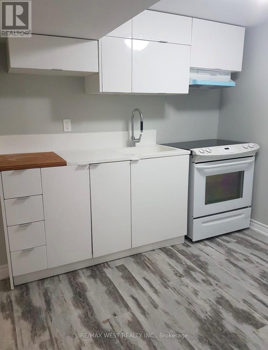 A white kitchen with a stove and a sink.