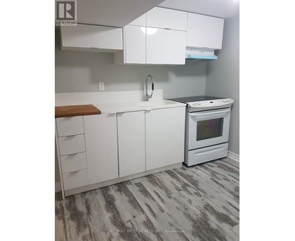 A white kitchen with a stove and a sink.