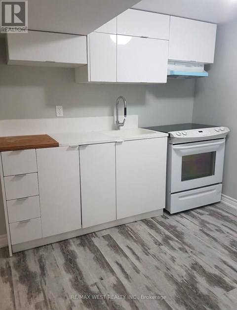A white kitchen with a stove and a sink.