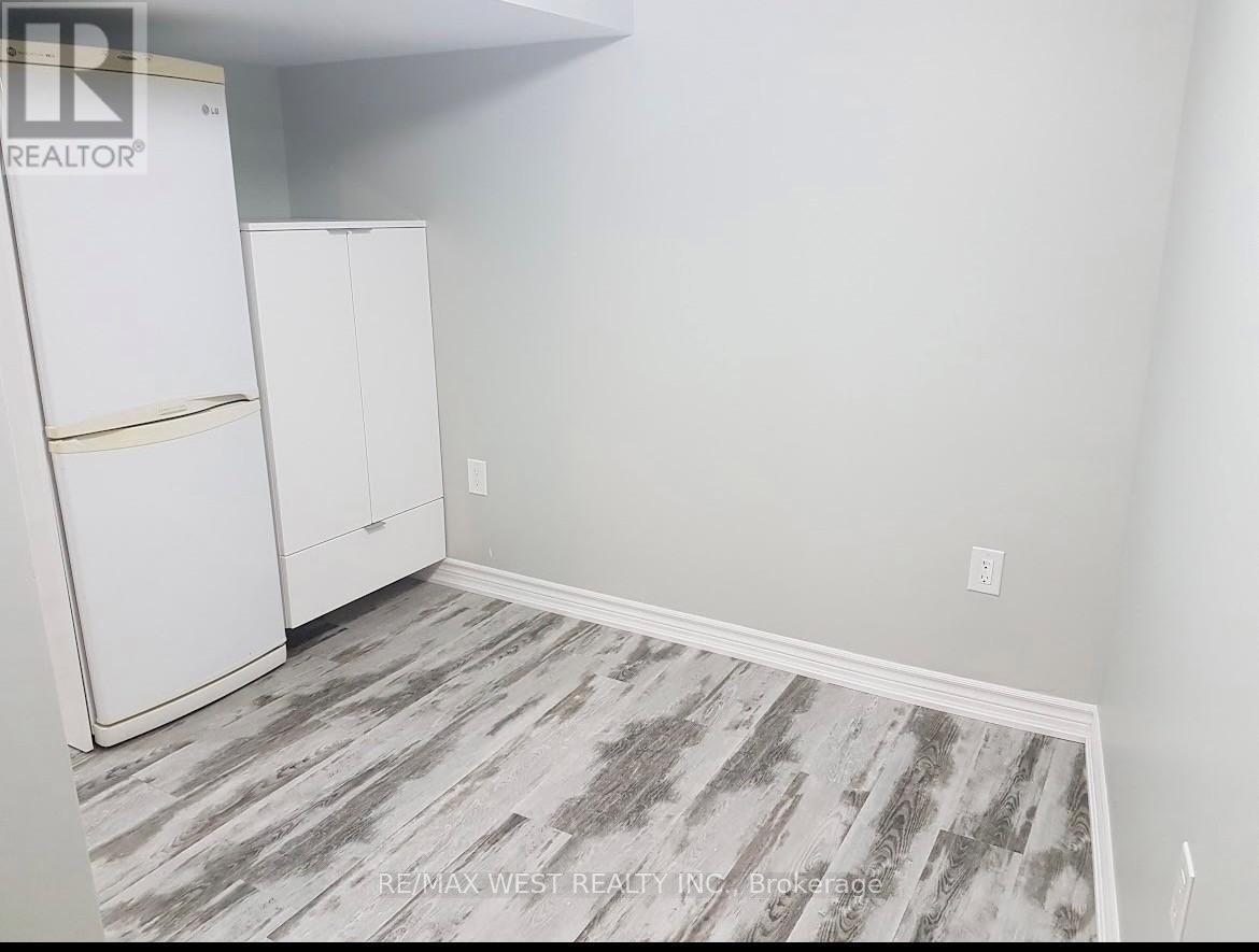 A room with a white fridge and cabinets.