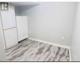 A room with a white fridge and cabinets.
