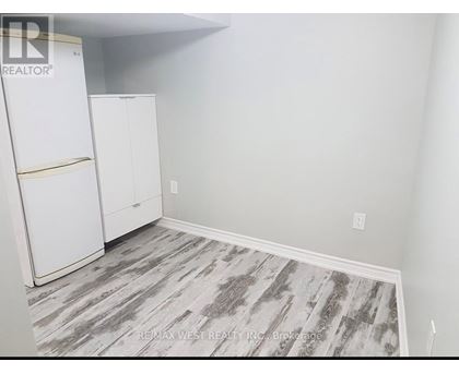 A room with a white fridge and cabinets.