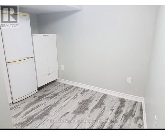 A room with a white fridge and cabinets.