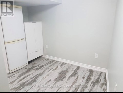 A room with a white fridge and cabinets.
