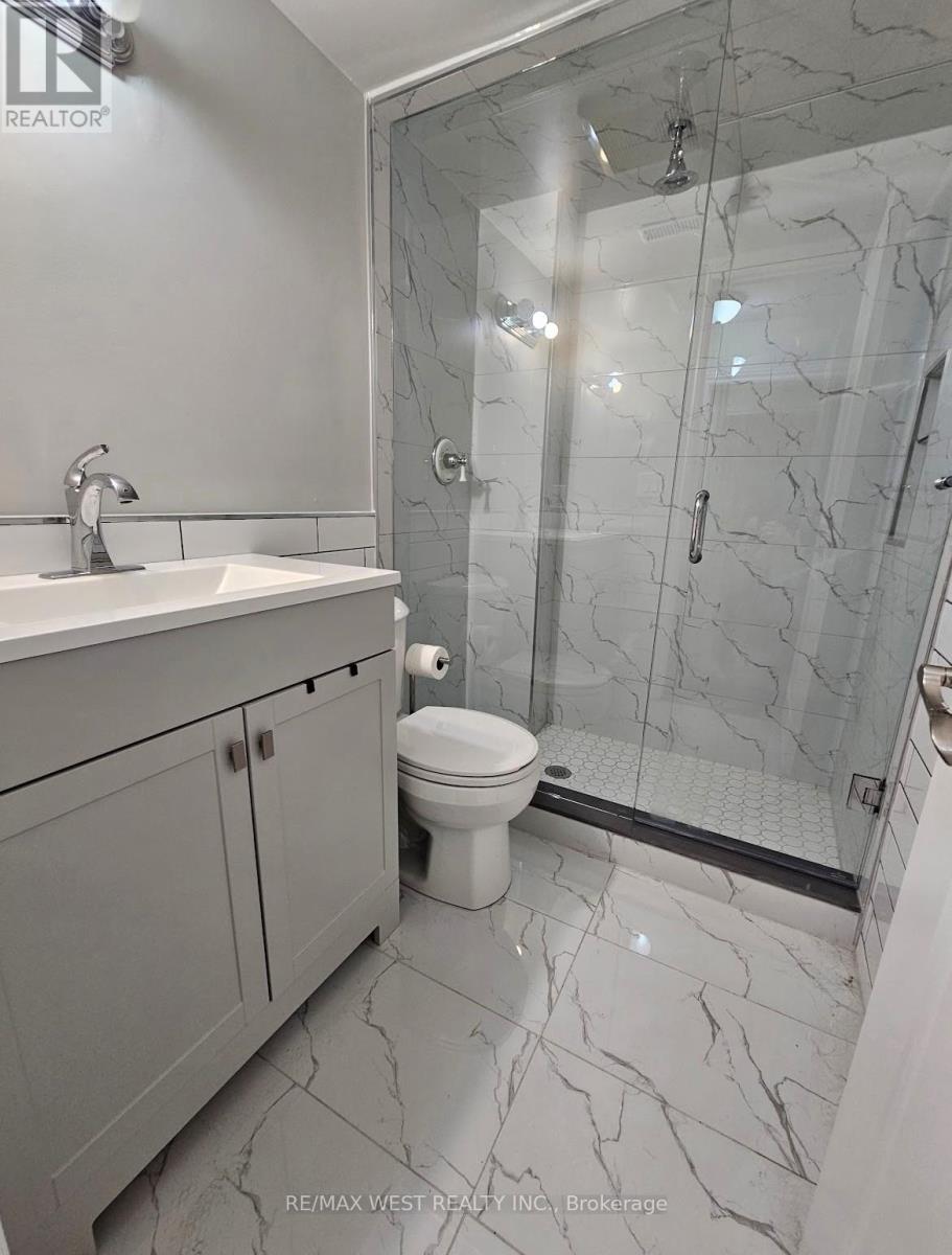 A bathroom with a marble floor and a walk-in shower.