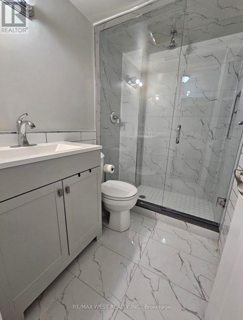 A bathroom with a marble floor and a walk-in shower.