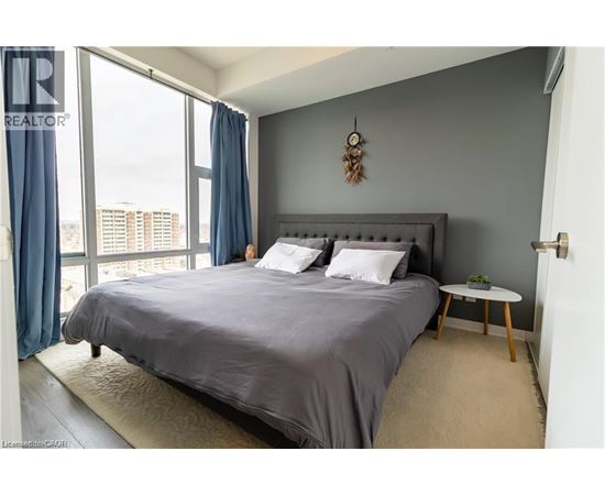 A bedroom with a large bed and a view of the city.