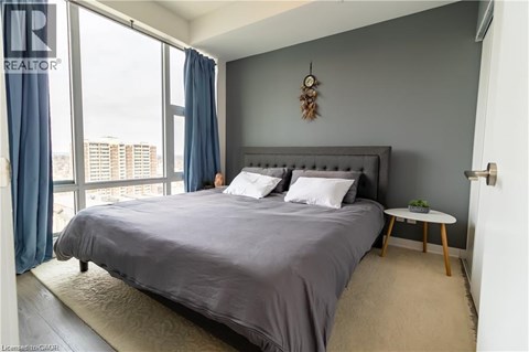 A bedroom with a large bed and a view of the city.