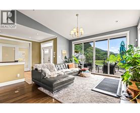 A living room with a grey couch and a chandelier.