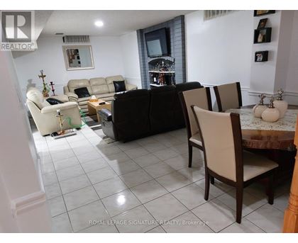 A living room with a black couch and a white sofa.