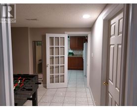 A room with a pool table and a door leading to another room.