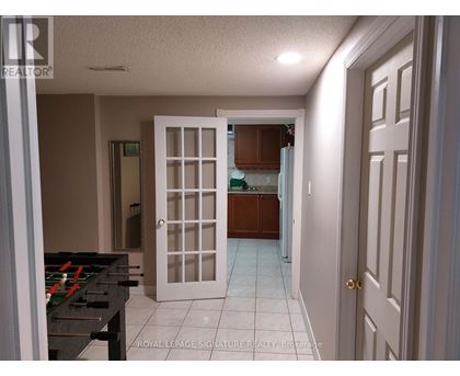 A room with a pool table and a door leading to another room.