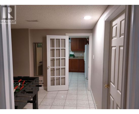 A room with a pool table and a door leading to another room.