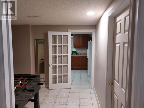 A room with a pool table and a door leading to another room.