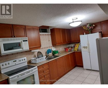 A kitchen with brown cabinets and white appliances.