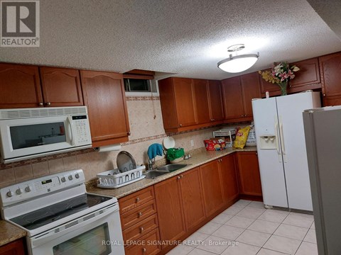 A kitchen with brown cabinets and white appliances.