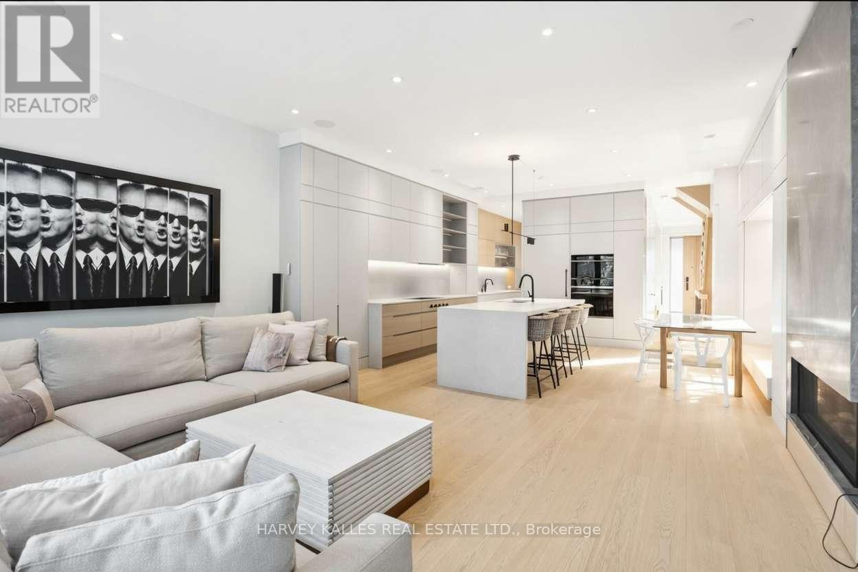 A modern living room with a large painting on the wall and a dining area in the background.